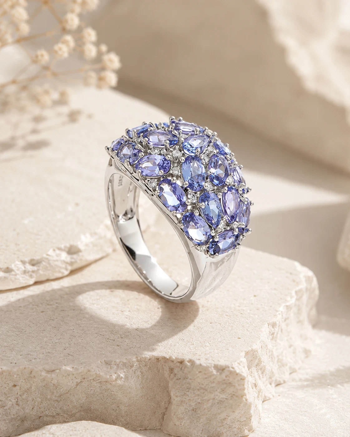 The same ring seen close and from above, the dome of oval tanzanites filling the frame.